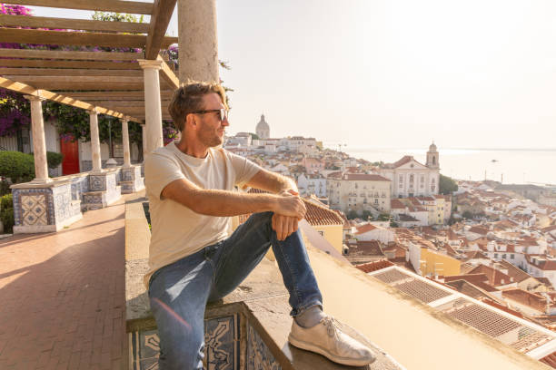 istock Man Sitting on Traditional Terrace Overlooking Lisbon's Alfama District 2156783146
