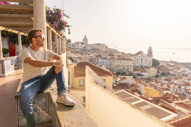 istock Man Sitting on Traditional Terrace Overlooking Lisbon's Alfama District 2156783147