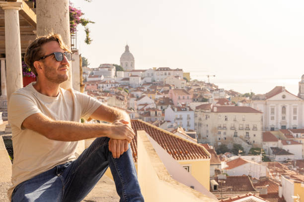 istock Man Sitting on Traditional Terrace Overlooking Lisbon's Alfama District 2156783160