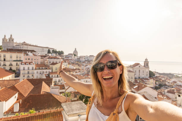istock Woman Joyfully Taking Selfie with Cityscape View 2156783337