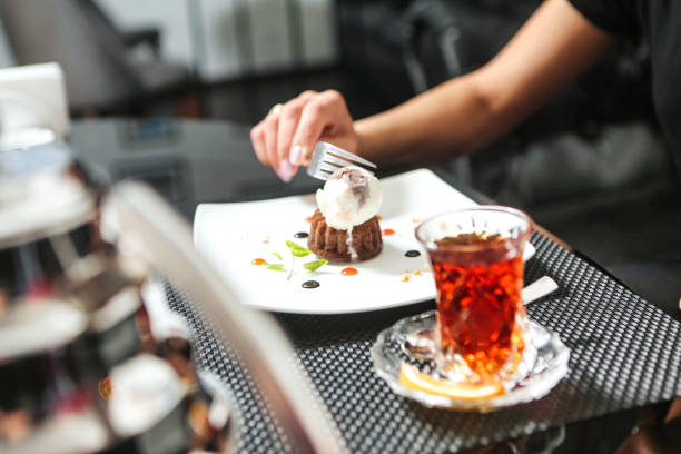 istock Person Cutting Into Chocolate Cake on White Plate 2156783438