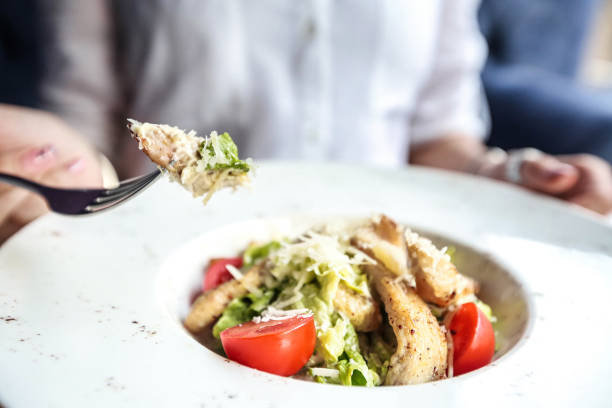 istock Person Eating Salad With Fork at a Restaurant Table 2156783586