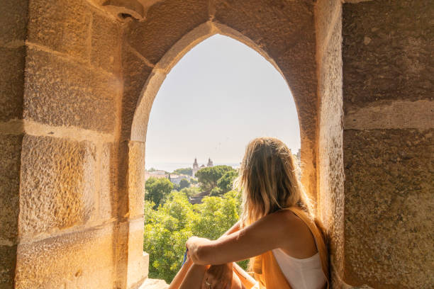 istock Woman Enjoying Sunlight at Ancient Stone Archway 2156784142