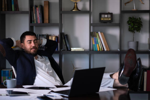 istock Businessman leaning on his chair with his hands behind his head looking at the computer 2156784276