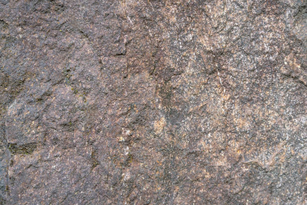 istock Dark, rough stone background with light-colored veins of various colors. 2156786222