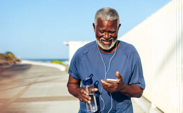 istock Senior African American man smiling while using smartphone on promenade 2156788765