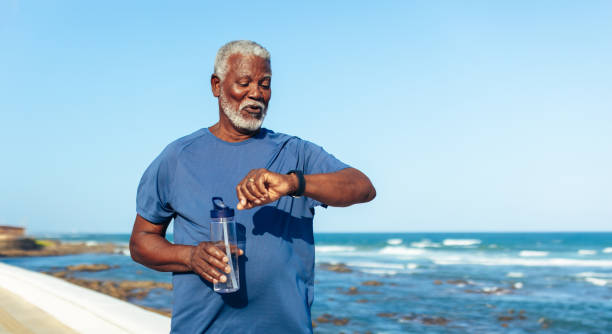 istock Active senior African American man checking time by the sea 2156788834