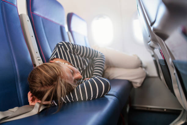 istock Young woman is sleeping on empty seats in the plane 2156792764