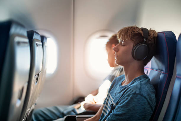 istock Teenage boys sleeping in plane 2156797815