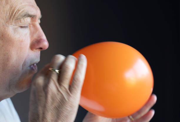 Side-view of an African-American man with closed eyes. hit by a deformed water balloon.