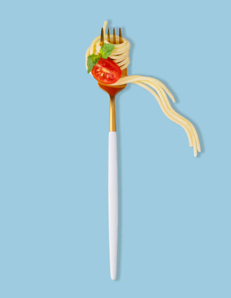 istock Spaghetti on a fork with a piece of tomato, sauce and basil on a blue  background. 2156800949