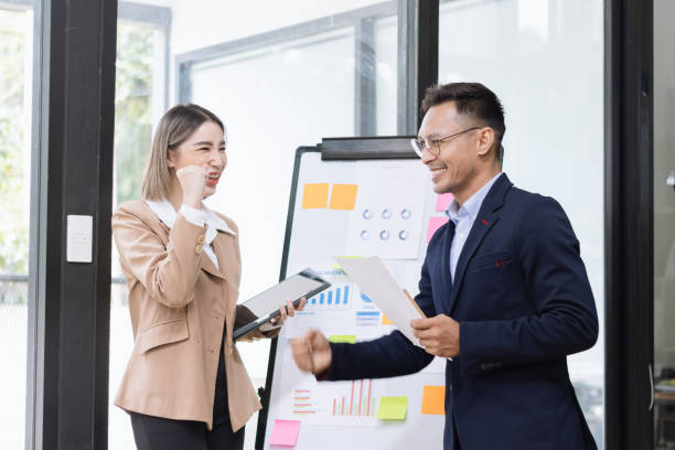 istock Asian coworkers standing up and looking document paper  together in office. 2156801907