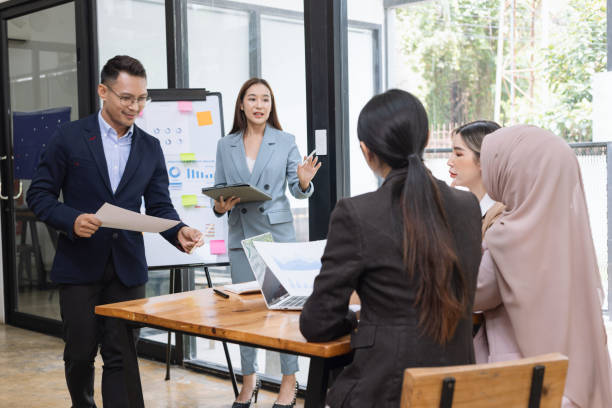 istock Group of asian business people working and brainstorming in workshop and analyzing marketing reports startup project infographics in the office. 2156802131