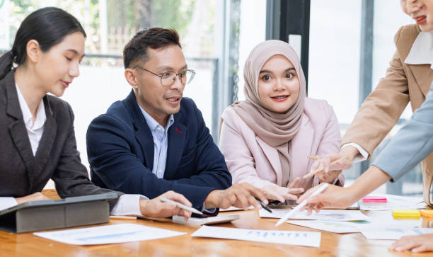 istock Group of asian business people working and brainstorming in workshop and analyzing marketing reports startup project infographics in the office. 2156802455