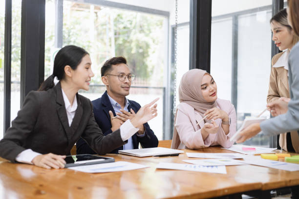 istock Group of asian business people working and brainstorming in workshop and analyzing marketing reports startup project infographics in the office. 2156802497