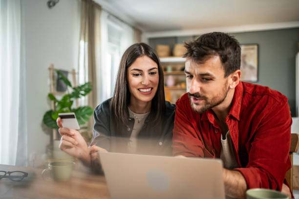 istock Young couple in love using laptop for online shopping 2156803156