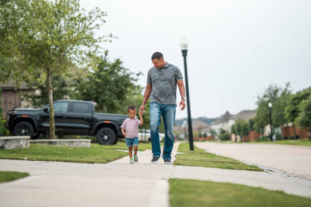 istock Diverse Father and Child Enjoying a Sidewalk Stroll 2156804574