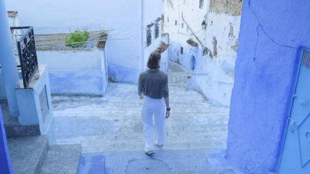 istock Young woman explores colourful, narrow streets 2156807714