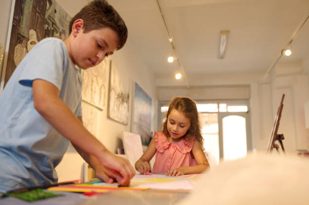 istock Children enjoying art class with teacher, drawing and painting in a creative workshop 2156809216