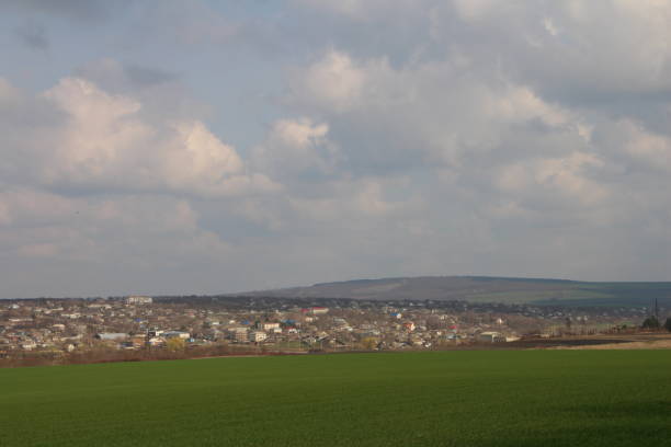 istock A large green field with a town in the distance 2156812877