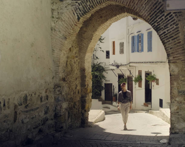 istock Young woman walks under stone arch 2156812944