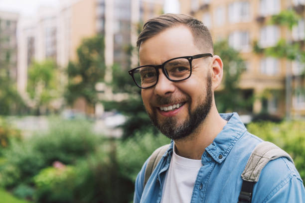 istock Close up portrait of young handsome casually dressed man posing outdoors, smiling and looking looking  to the camera 2156814204