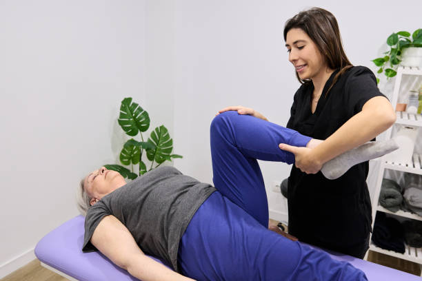 istock Happy physiotherapist with old woman performs lower limb mobilization in physiotherapy center 2156814382