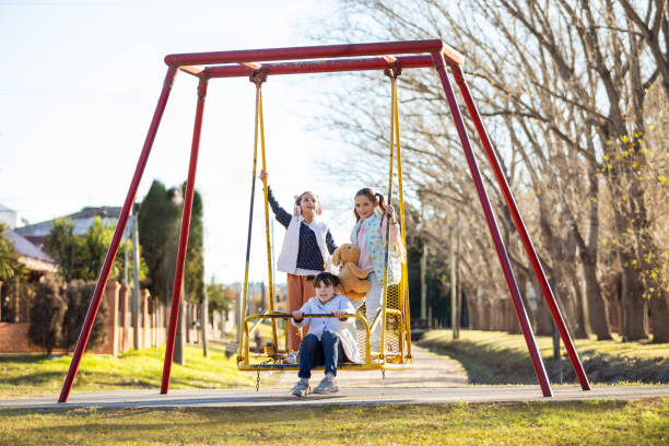 istock Happy girls swinging on the playground 2156822012