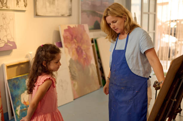 istock Teacher guiding a child during an art class in a creative workshop setting 2156824810