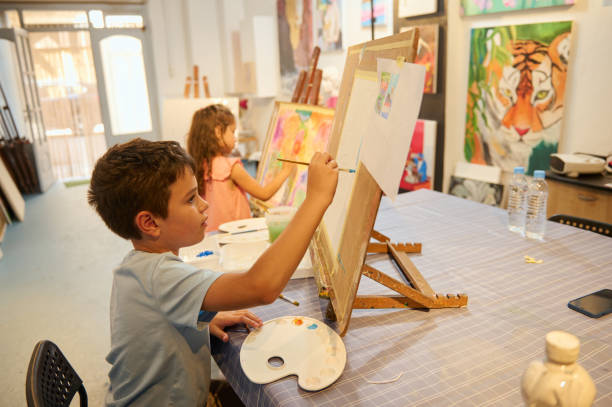 istock Kids painting and drawing in art class with teacher in workshop environment 2156825799