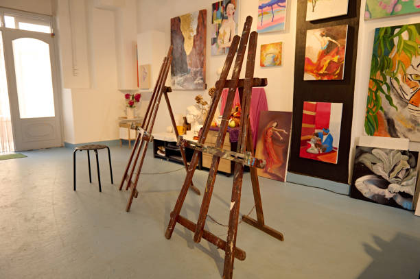 istock Art studio with easels and colorful paintings on display against white walls 2156828587