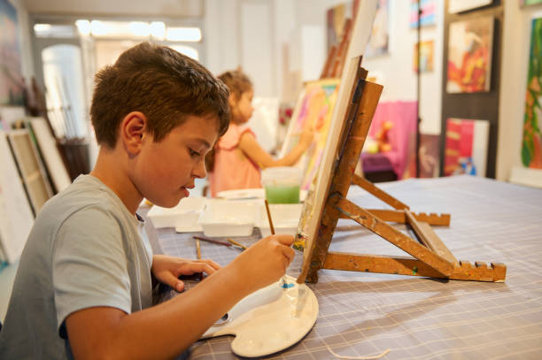 istock Kids engaged in art class, drawing and painting with teacher in creative workshop 2156830276