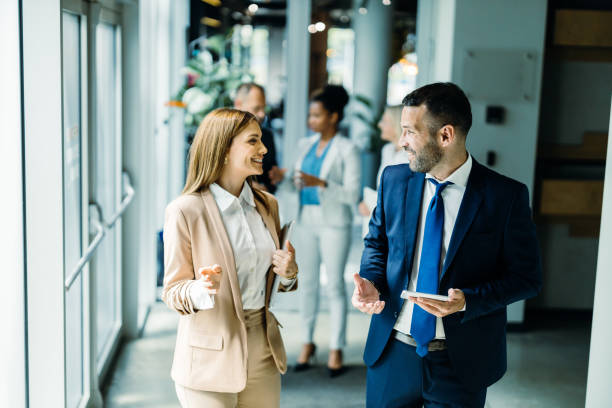 istock Two professionals chatting in a lively corridor 2156838198