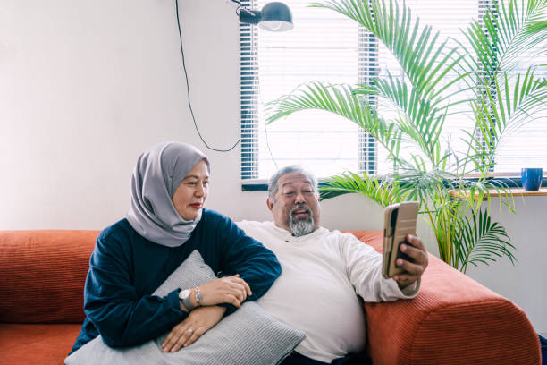 istock Happy Senior Couple Video Calling from Phone at Home 2156838263