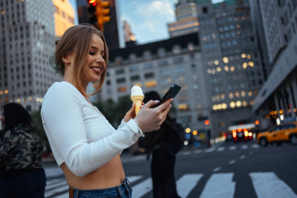 istock Smiling woman holds ice cream & phone 2156838767