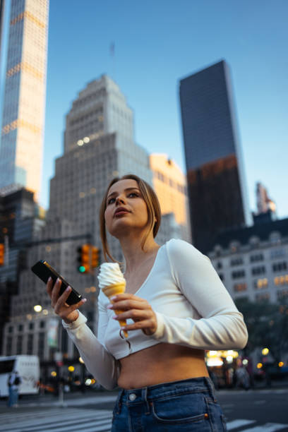 Wistful woman with ice cream in urban setting
