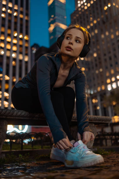 istock Sportswoman tying shoe with skyline 2156838777
