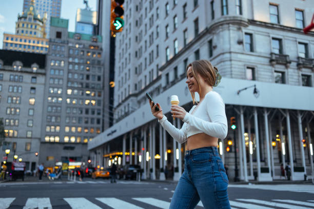 istock Lady walking and checking phone in city 2156838781