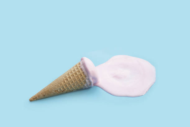 istock Melting ice cream ball with waffle cone on blue background. 2156839815