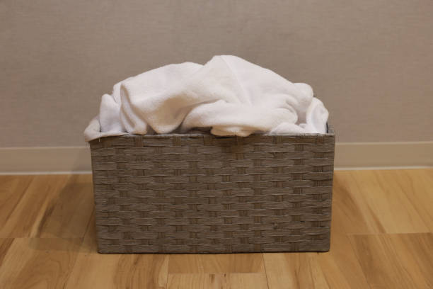 Close-up of a laundry basket full of dirty washing. Blue background.