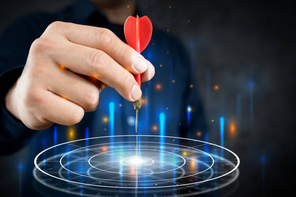 istock Businessman throwing red arrow dart to virtual target dart board. 2156845045