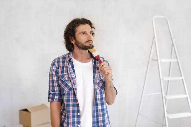 istock Thoughtful Man Holding Paintbrush Planning Home Renovation 2156849151