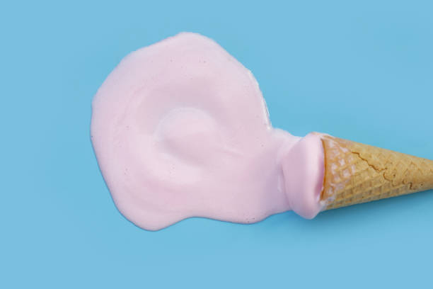 istock Melting ice cream ball with waffle cone on blue background. 2156849341