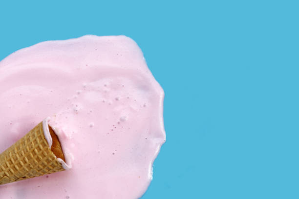 istock Melting ice cream ball with waffle cone on blue background. 2156849343