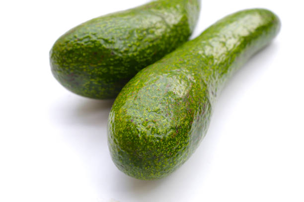 Fresh healthy green avocado on market as background. Agriculture. Food background. Close up.