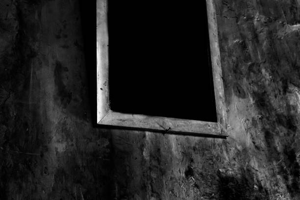 the window frames in the room are dark and scary
