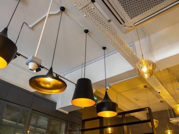 istock Row of various modern lights hanging from white ceiling building decorations in room, loft style. Many black vintage retro style of lamps installed in cafe, restaurant or house interior ideas. 2156856778