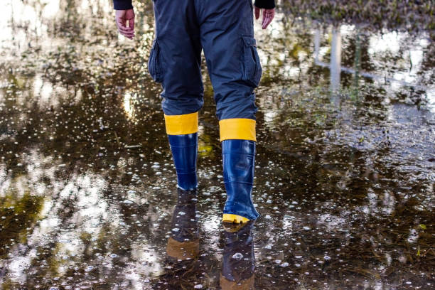 yellow rubber boots in floods symbolic image