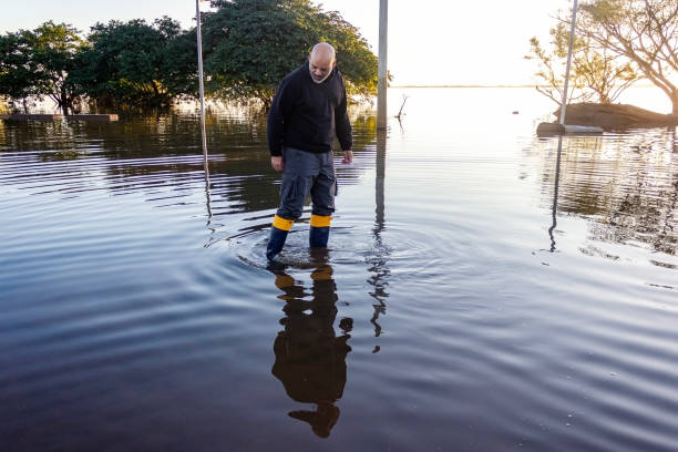 Middle-aged man walking in flooded area
