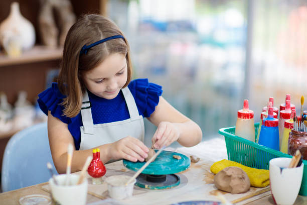 istock Child at pottery wheel. Kids arts and crafts class 2156860887